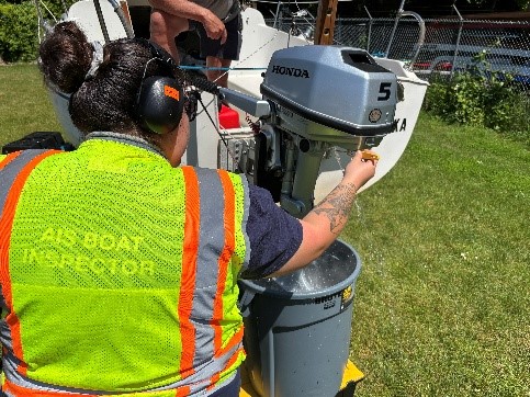 decon picture Inspector removing water from boat's internal system during a decontamination